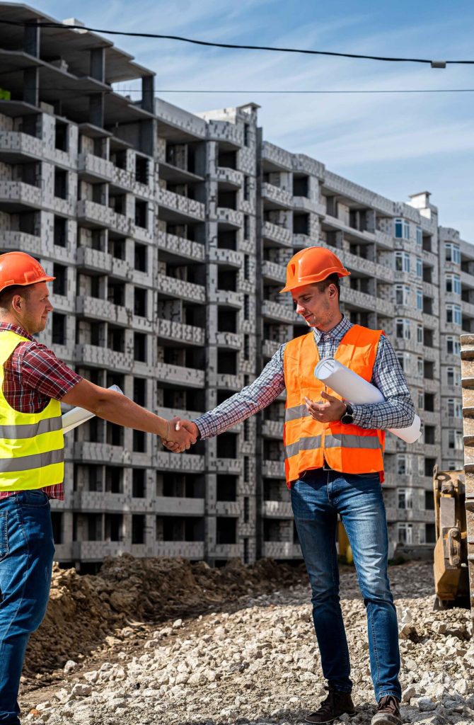 two-good-workers-uniform-helmets-shake-hands-near-grader-new-building-construction-concept_11zon